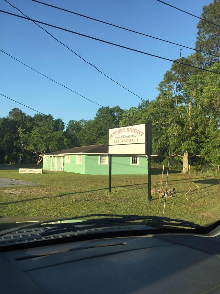 The green Jeffrey Knight Family Dentistry office and road sign on Shaw Drive in Gautier